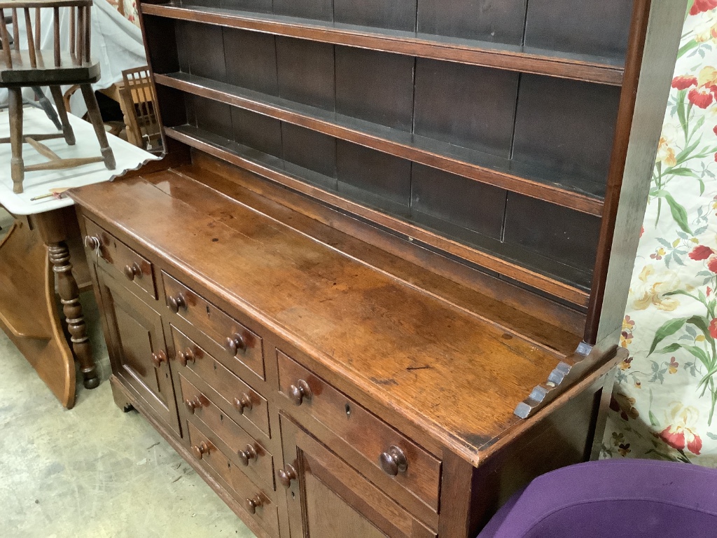 An early 19th century oak dresser with boarded rack, length 174cm, depth 48cm, height 210cm